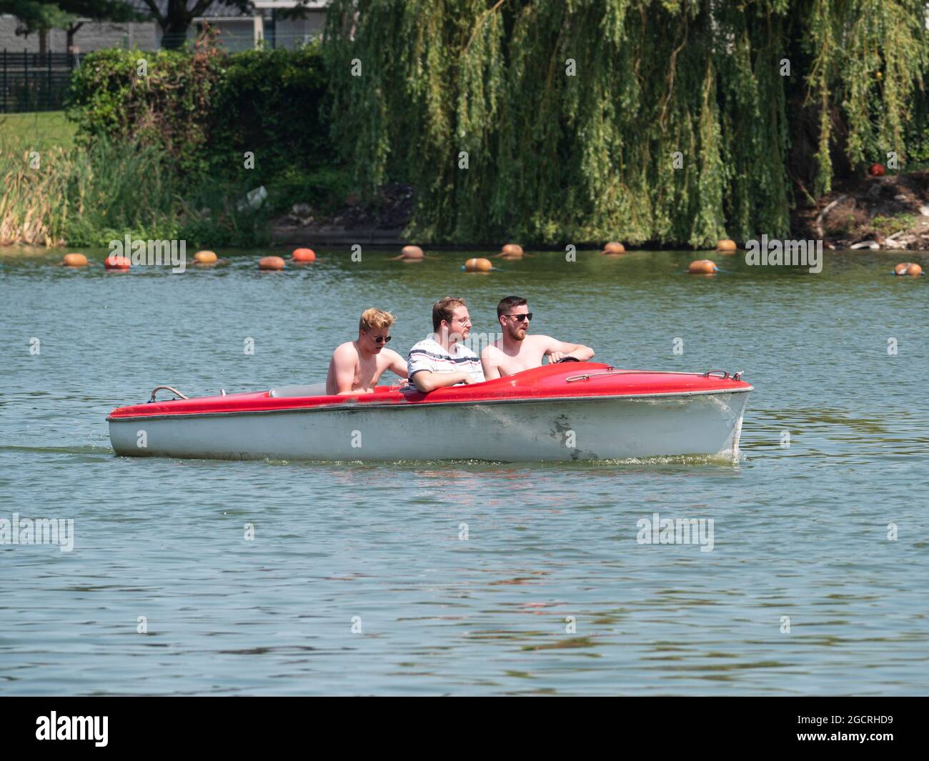 Berlare, Belgio, 22 luglio 2021, tre amici si godono una gita in barca su un lago con una barca elettrica Foto Stock