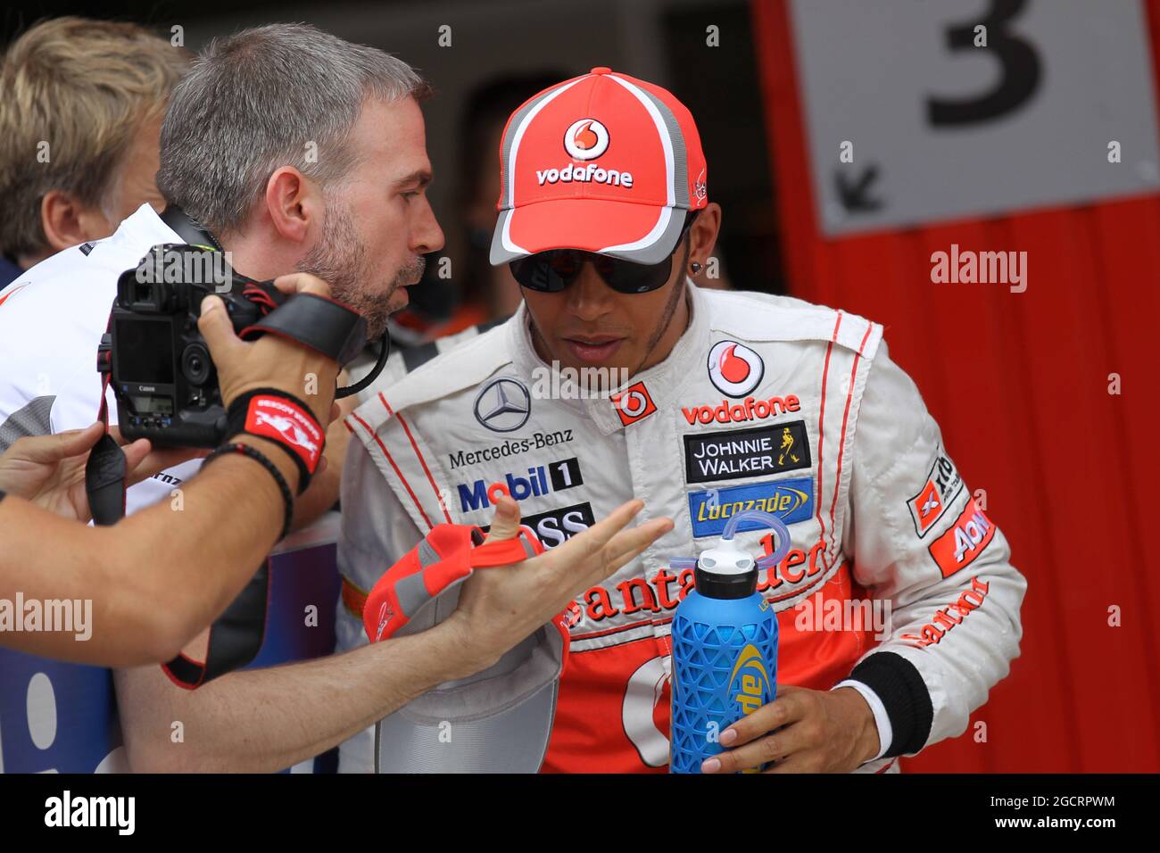 (Da L a R): Steve Cooper (GBR) McLaren Press Officer parla con il pole sitter Lewis Hamilton (GBR) McLaren nel parc ferme dopo le qualifiche. Gran Premio di Spagna, sabato 12 maggio 2012. Barcellona, Spagna. Foto Stock