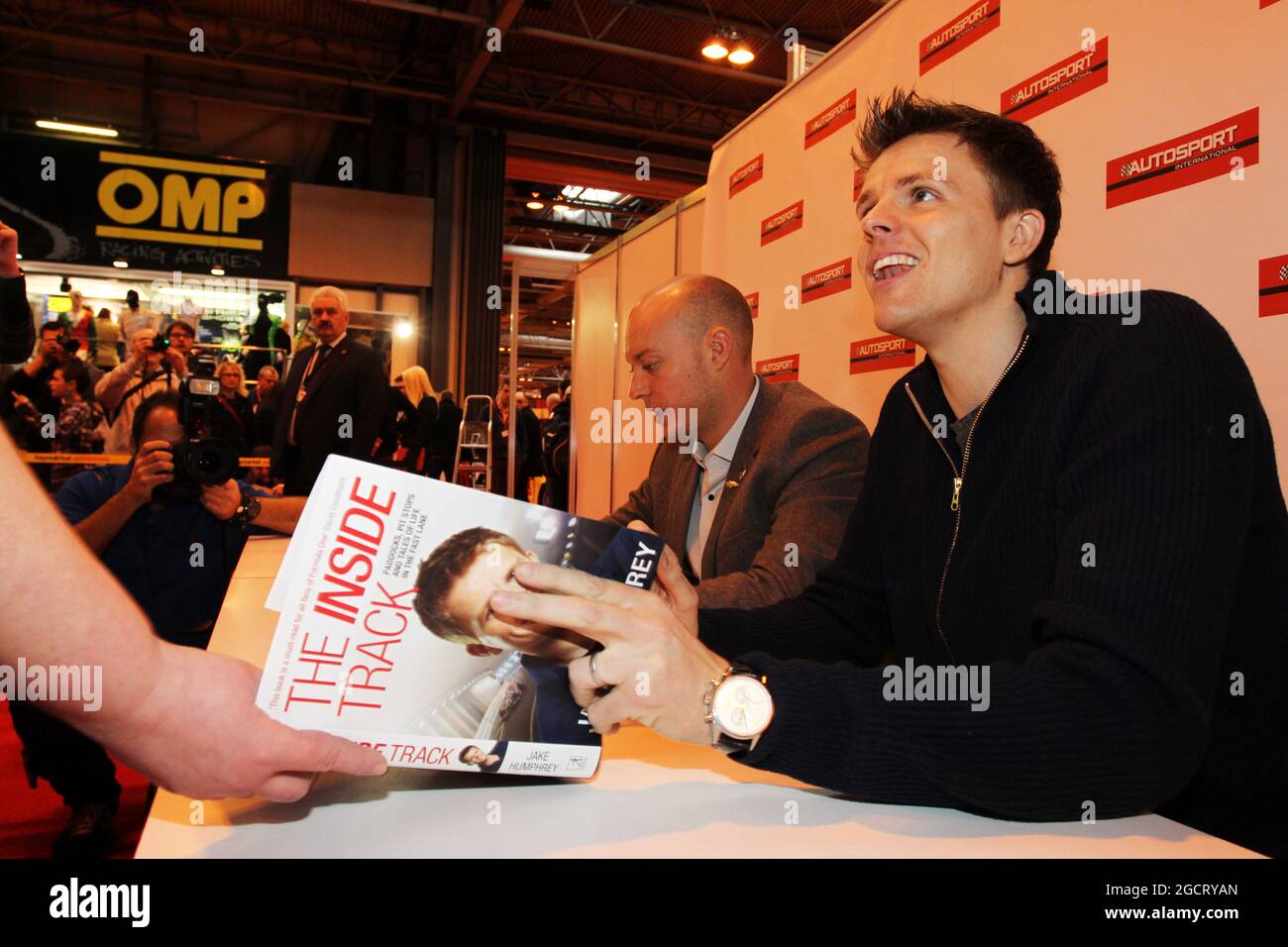 Rob Huff e Jake Humphrey (GBR) firmano autografi per i fan. Autosport International, sabato 12 gennaio 2013. National Exhibition Centre, Birmingham, Inghilterra. Foto Stock