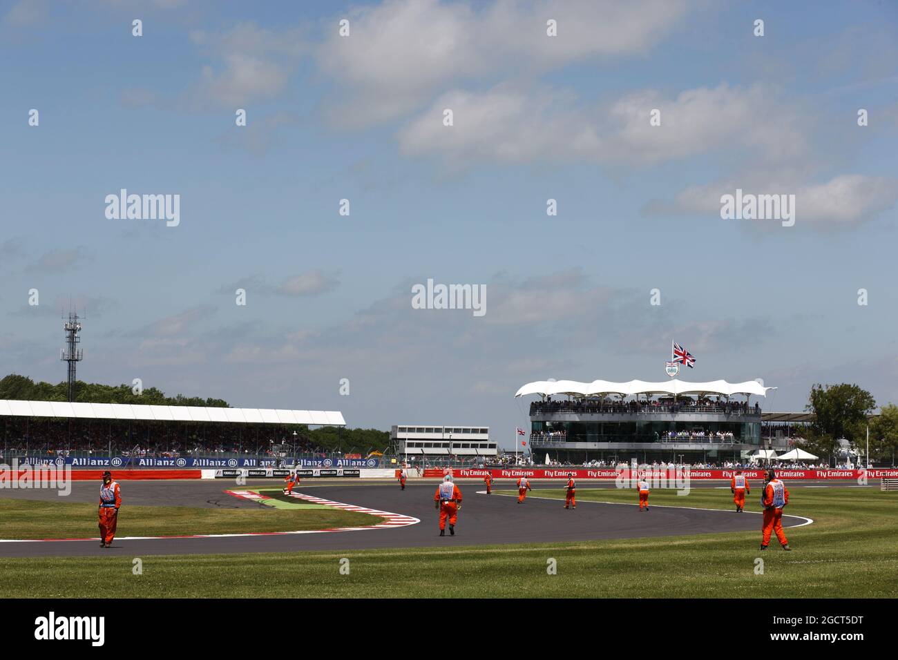 I marshal arrivano sul circuito per eliminare i detriti dal cingolo. Gran Premio di Gran Bretagna, domenica 30 giugno 2013. Silverstone, Inghilterra. Foto Stock