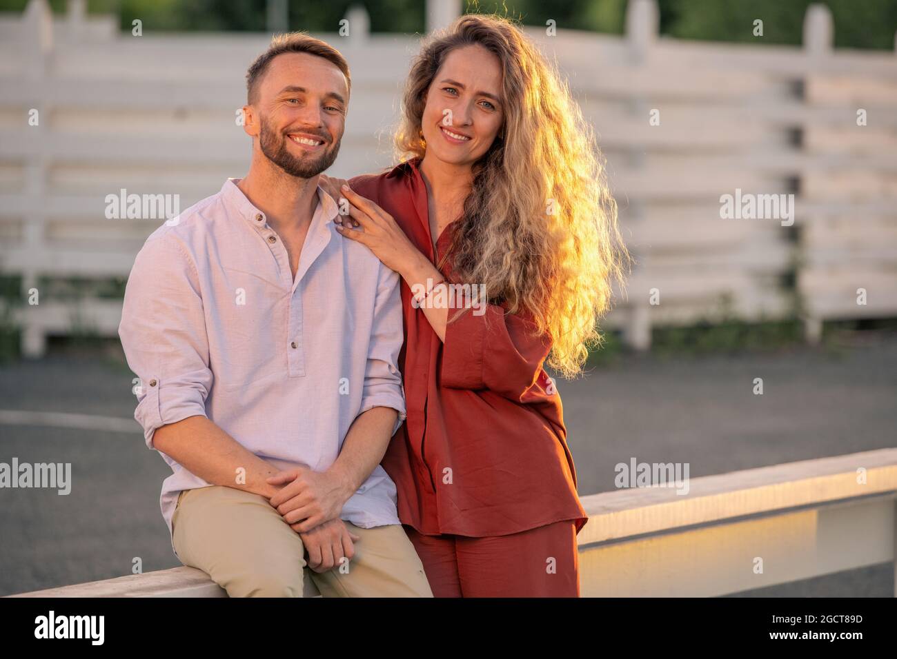 Felice giovane coppia in casualwear godendo di una giornata di sole in campagna Foto Stock