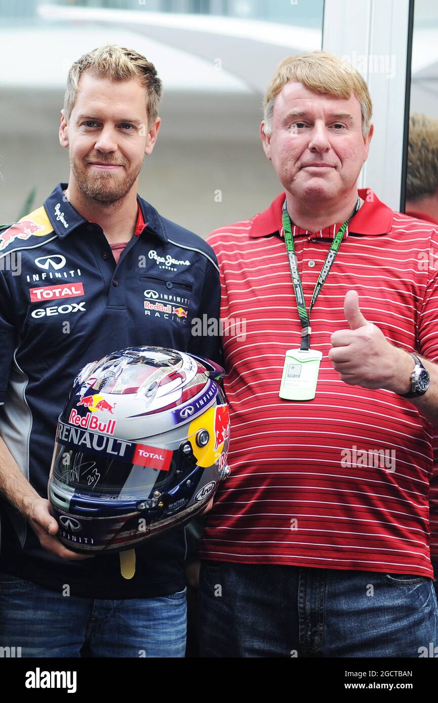 Rolf Carsjens (a sinistra), vincitore del concorso per progettare il casco del GP degli Stati Uniti Sebastian Vettel (GER) Red Bull Racing (a destra). Gran Premio degli Stati Uniti, giovedì 14 novembre 2013. Circuito delle Americhe, Austin, Texas, USA. Foto Stock