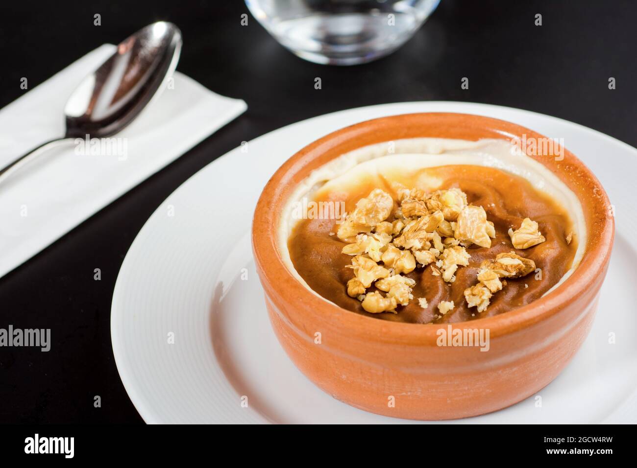 Sutlac Turco o Pudding di riso al forno con nocciole in ciotola di argilla. Foto Stock