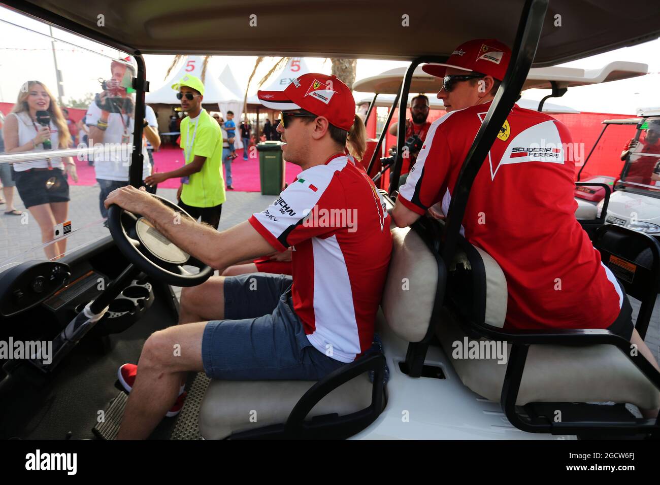 Sebastian Vettel (GER) Ferrari guida un golf buggy con Kimi Raikkonen (fin) Ferrari e Britta Roeske (AUT) Ferrari Press Officer. Gran Premio del Bahrain, venerdì 17 aprile 2015. Sakhir, Bahrein. Foto Stock