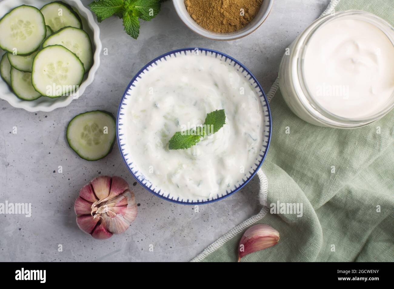 Tradizionale raita indiana con cetriolo, yogurt greco e coriandolo, vista dall'alto, sfondo in cemento Foto Stock