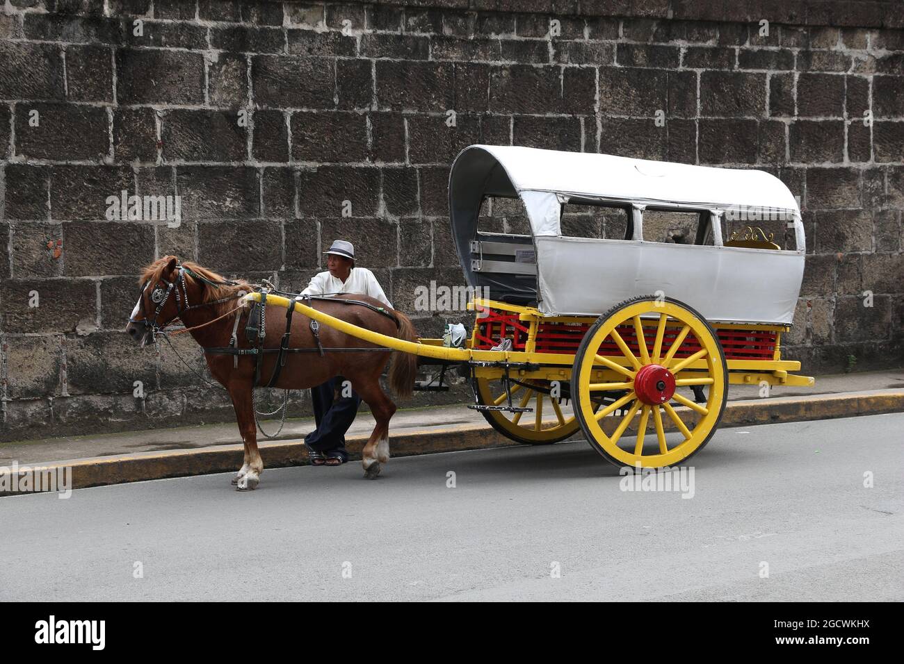 MANILA, FILIPPINE - 25 NOVEMBRE 2017: L'autista si trova in carrozza a cavallo nel distretto di Intramuros, Manila, Filippine. Le escursioni a cavallo sono una touris popolare Foto Stock