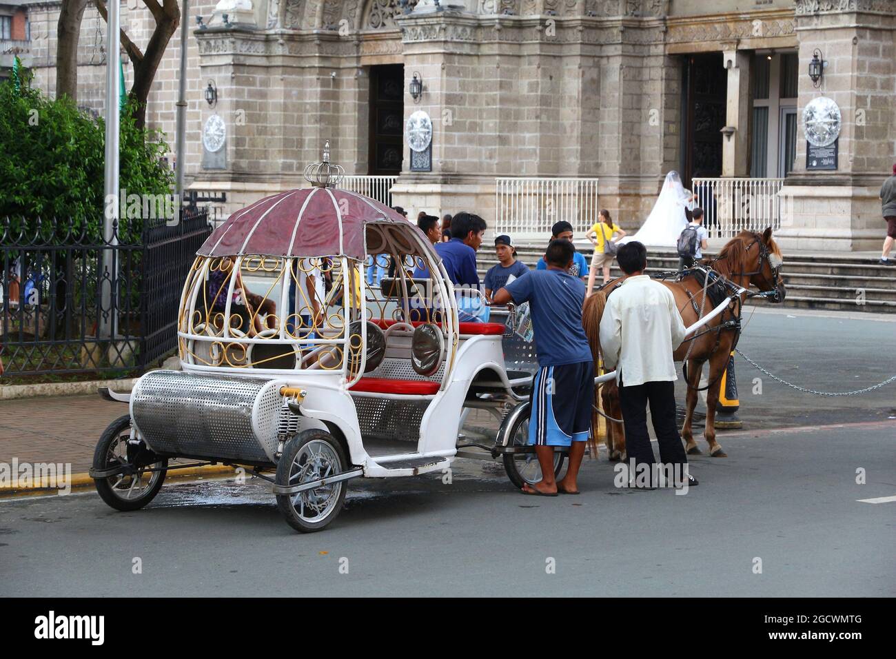 MANILA, FILIPPINE - 25 NOVEMBRE 2017: La gente si trova in carrozza a cavallo nel distretto di Intramuros, Manila, Filippine. Le escursioni a cavallo sono un turista popolare Foto Stock