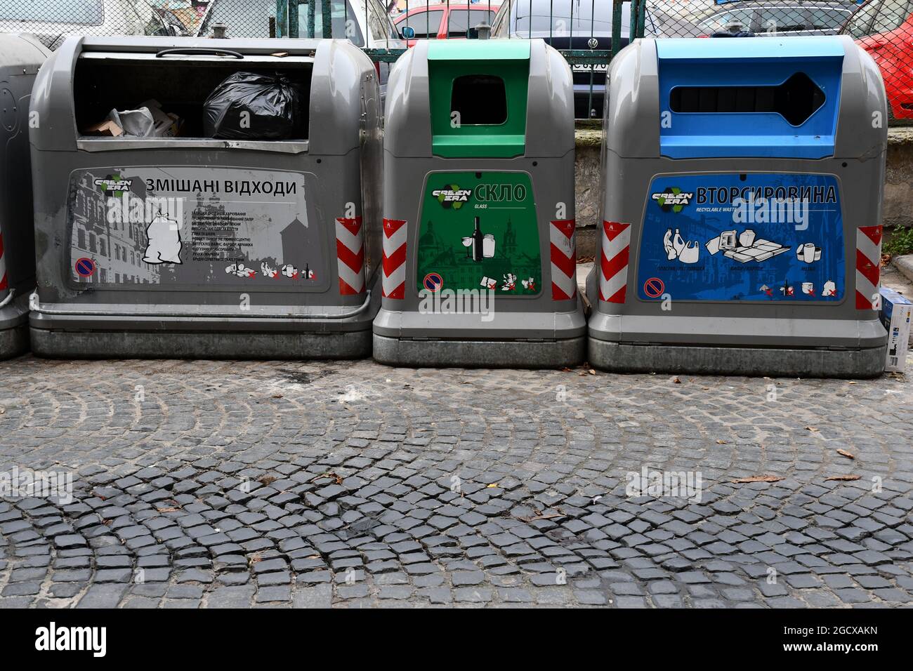 Contenitori separati per rifiuti e rifiuti riciclati. Concetto di economia verde e riciclaggio. Vari contenitori di rifiuti su acciottolato antico Foto Stock
