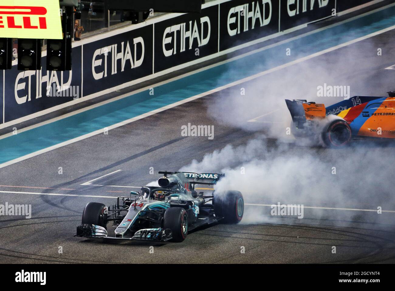 Il vincitore della gara Lewis Hamilton (GBR) Mercedes AMG F1 W09 e Fernando Alonso (ESP) McLaren MCL33 eseguono ciambelle alla fine della gara. Gran Premio di Abu Dhabi, domenica 25 novembre 2018. Yas Marina Circuit, Abu Dhabi, Emirati Arabi Uniti. Foto Stock