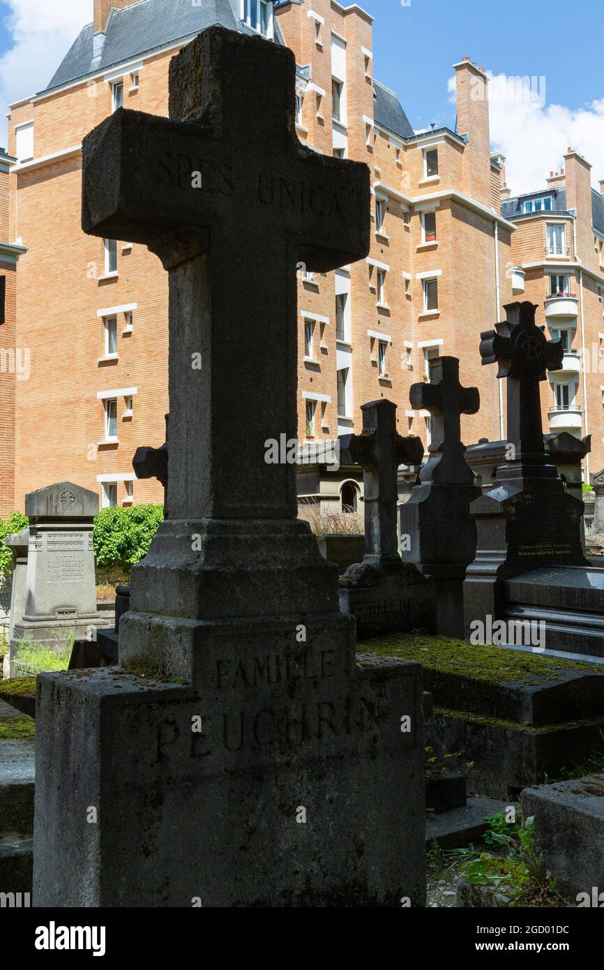 Sagome di croci di pietra dal cimitero di Père Lachaise che si staglia sullo sfondo di edifici residenziali. Parigi Foto Stock