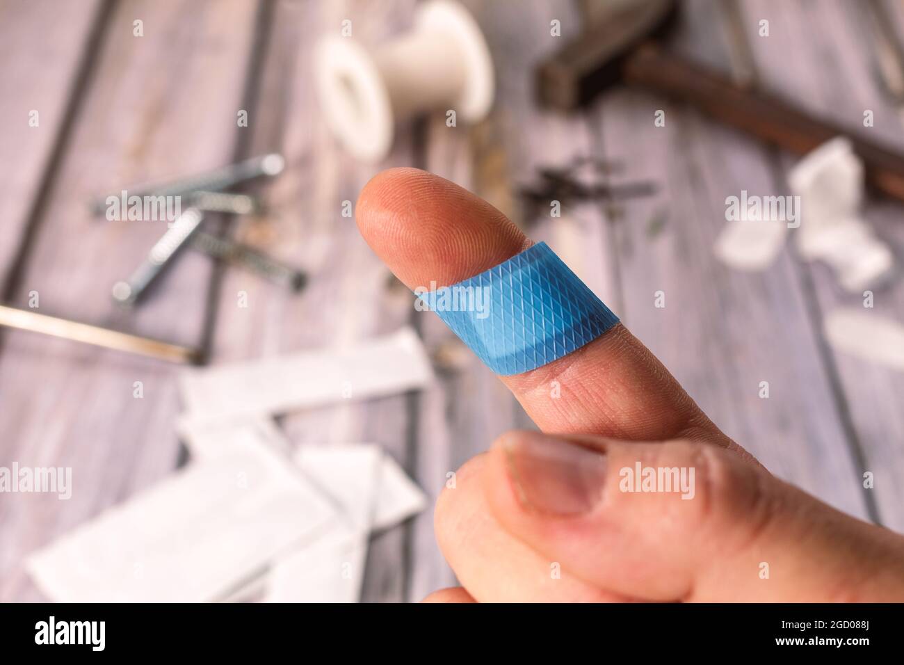Dito di un uomo caucasico con una banda-aiuto blu Foto Stock