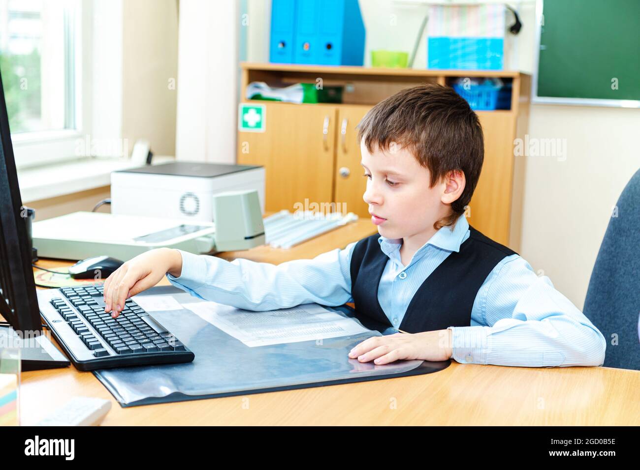 Scolaro serio in classe. Studente della scuola elementare. Ritorno a scuola. Foto Stock