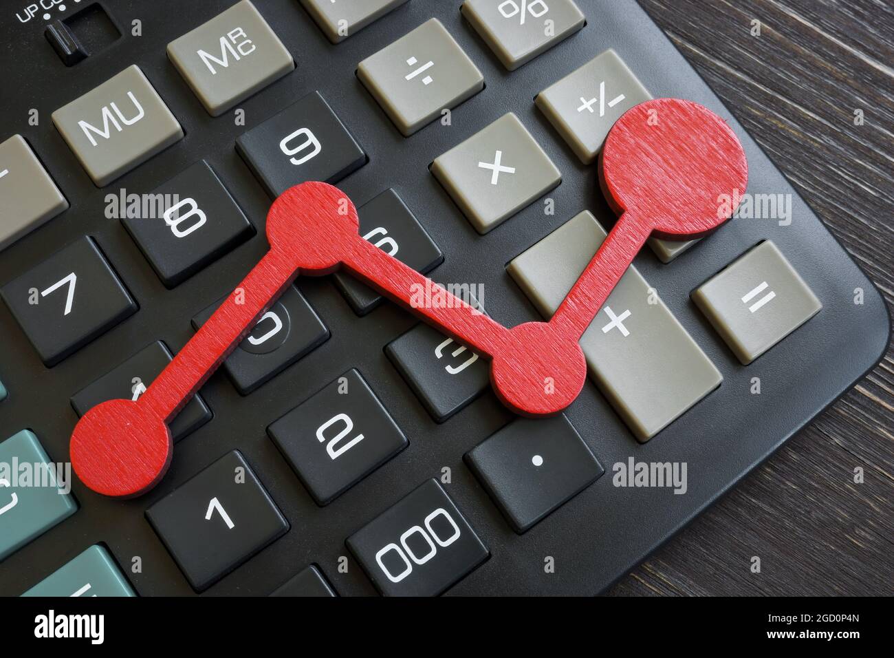 Grafico rosso su una calcolatrice. Statistiche aziendali e crescita del reddito. Foto Stock