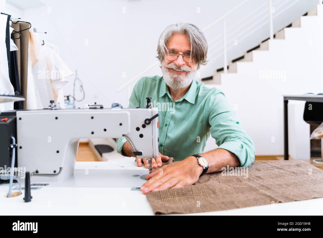 Stilista di abbigliamento creare un nuovo design per un abito - stilista di  moda che lavora su un marchio di abbigliamento in una fabbrica tessile Foto  stock - Alamy