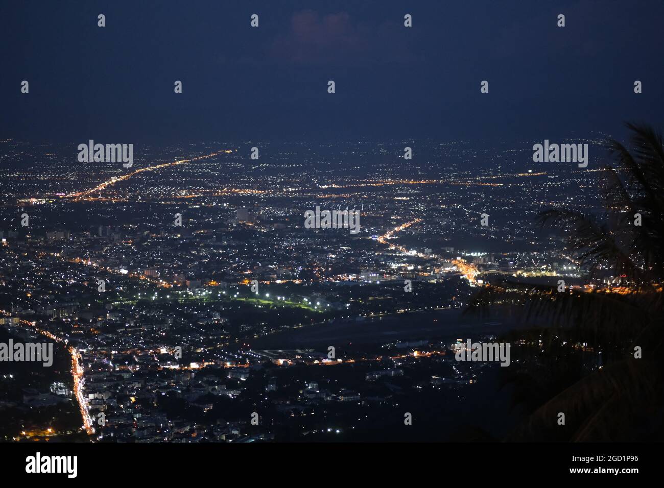 Vista mozzafiato delle luci notturne di una grande città (Chiang mai) da una collina vicina Foto Stock