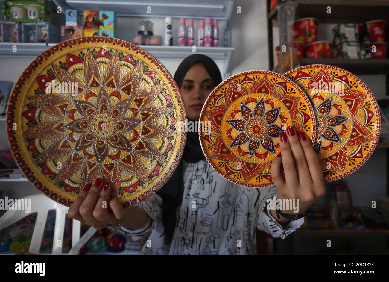 Jenin. 10 agosto 2021. Diaa Sbehat espone opere d'arte in ceramica fatte a mano con dipinti di motivi islamici alla sua bottega nella città di Jenin, West Bank, 10 agosto 2021. La Sbehat si era laureata alla al-Quds Open University con una laurea in tecnologia informatica e delle comunicazioni prima di iniziare a realizzare decorazioni in ceramica. Lei fa una vita vendendo i suoi lavori tramite i social media. Credit: Nidal Eshtayeh/Xinhua/Alamy Live News Foto Stock