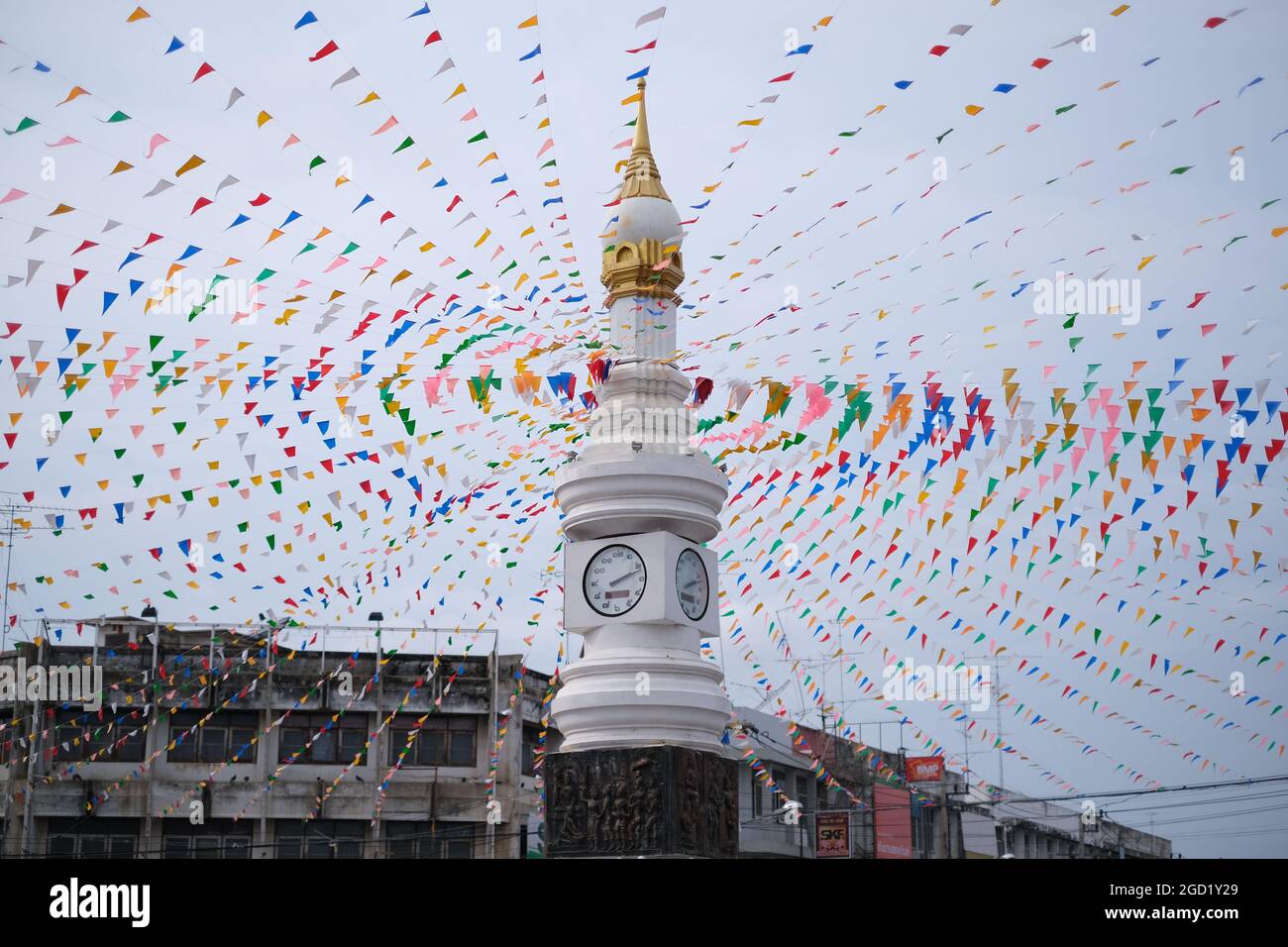 Una torre centrale dell'orologio della città di Sukhothai, lussuosamente decorata con piccole bandiere Foto Stock