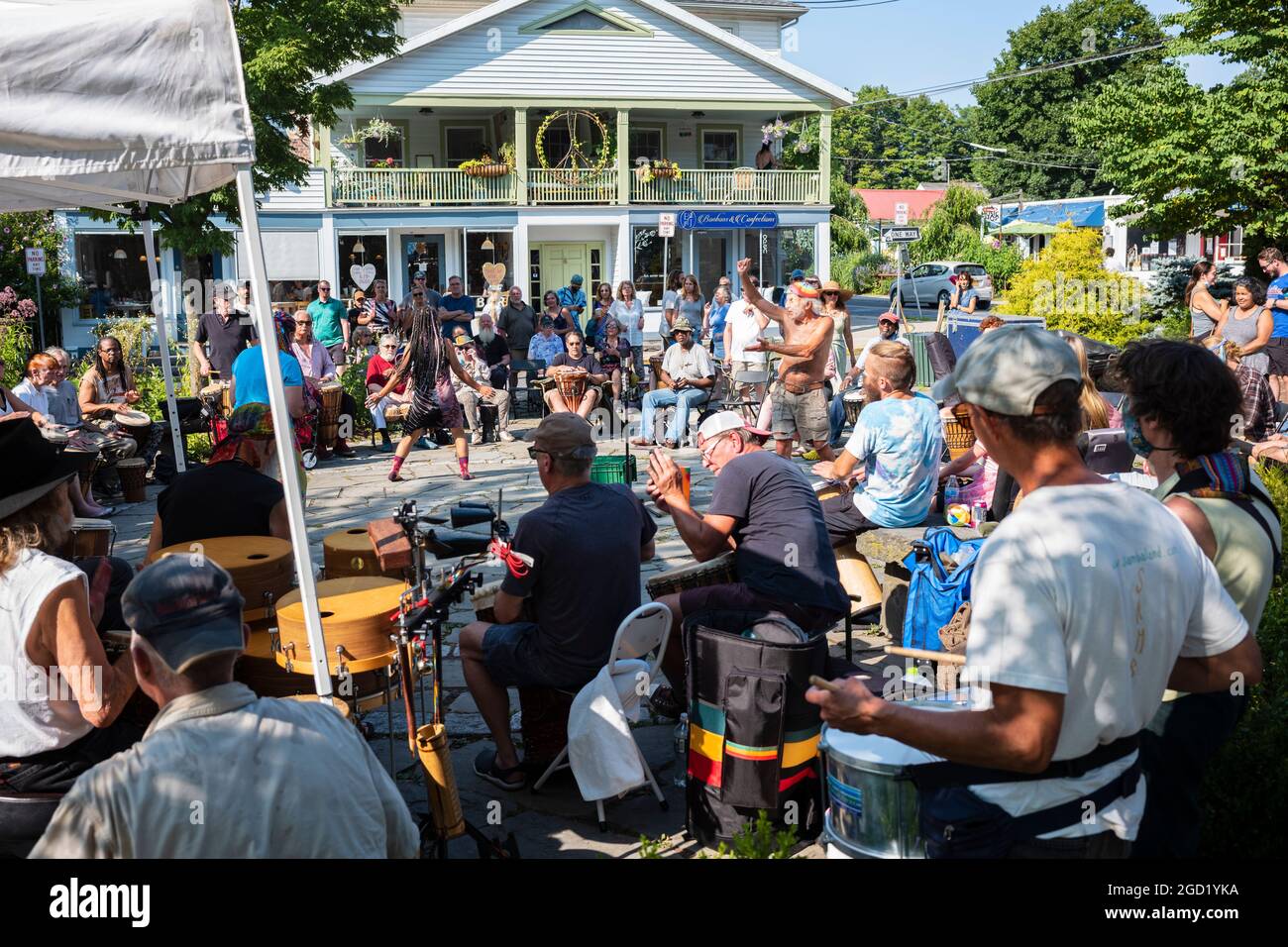 Woodstock, NY, USA - 8 agosto 2021: Un uomo e una donna ballano ai suoni di un circolo di tamburi della comunità tenuto al Village Green durante il pomeriggio estivo Foto Stock