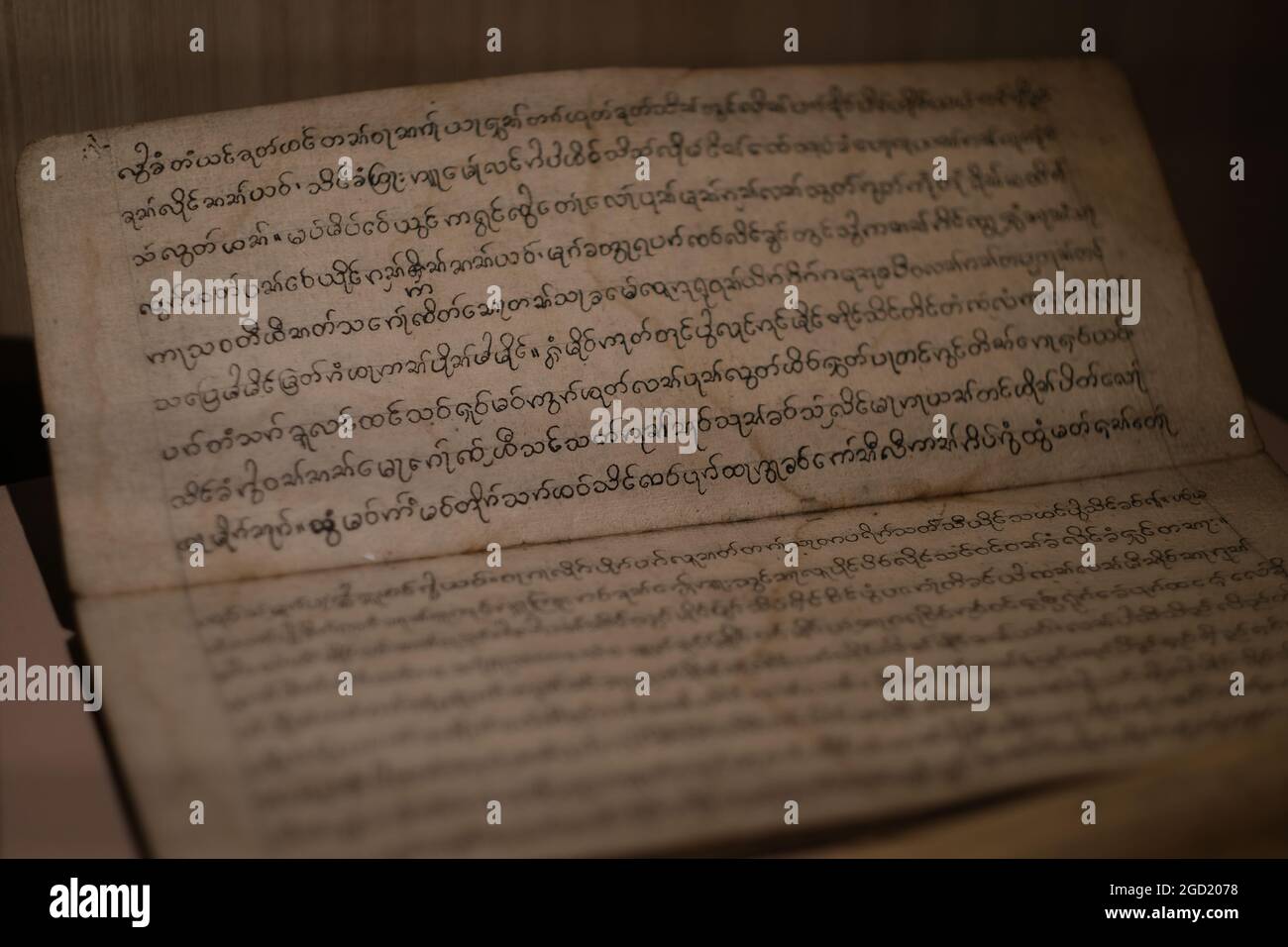 Pagine di un antico libro con testo scritto a mano, probabilmente in lingua vecchia Khmer, in un'esposizione in uno dei musei della Thailandia Foto Stock