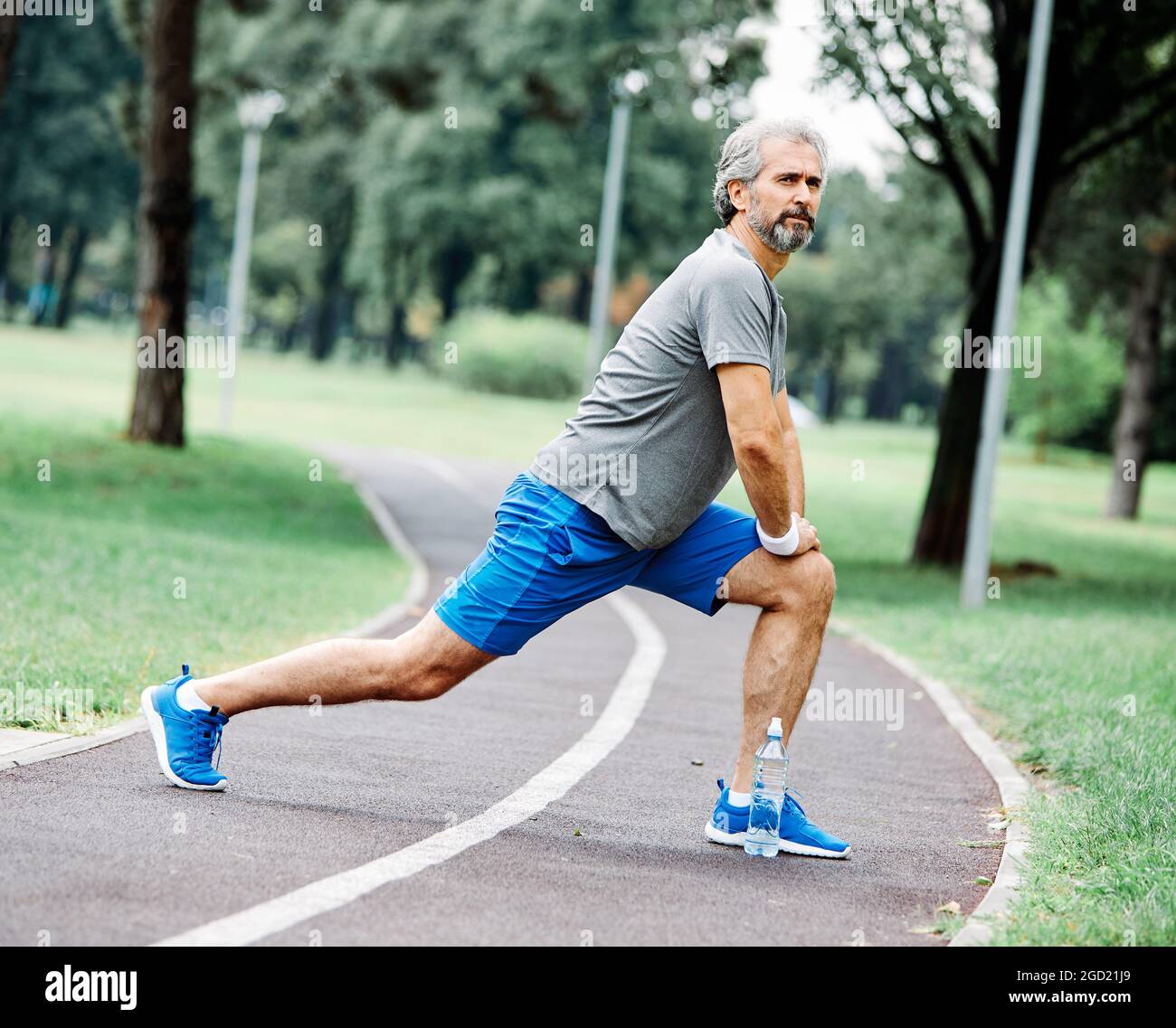 uomo anziano che corre esercitandosi sport idoneità attiva misura Foto Stock