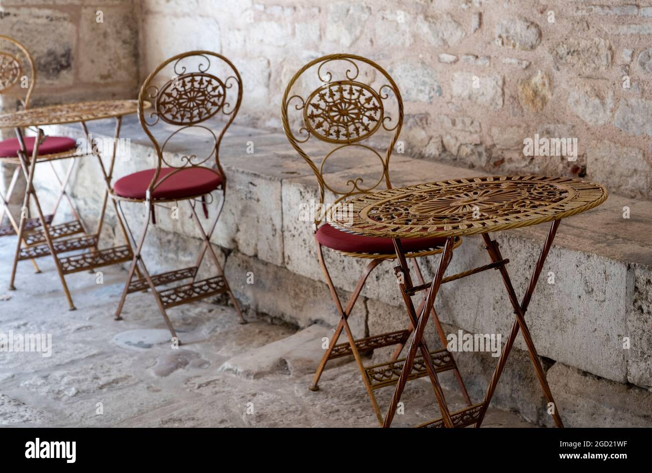 Sedie orientali e tavolo in un caffè popolare in Turchia accanto ad un muro di pietra. Foto Stock