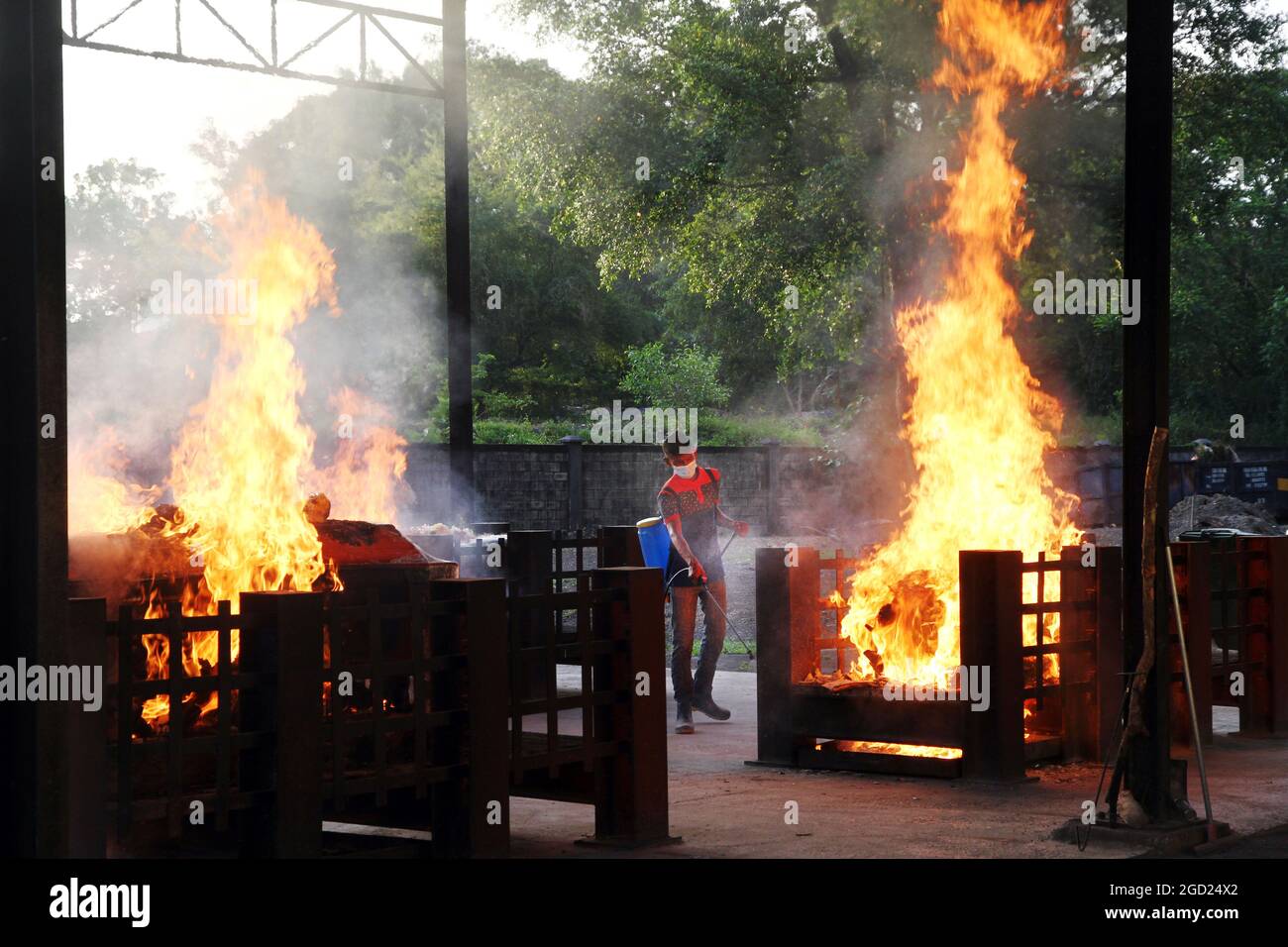 Kuala Lumpur, Malesia. 10 agosto 2021. Un operaio del tempio spruzzi disinfettante durante una cerimonia di cremazione delle vittime di Covid-19 ad un tempiale indù del crematorio a Kuala Lumpur, Malesia. Altri 201 decessi sono stati riportati oggi, portando il numero delle vittime a 11,162. (Credit Image: © Kamal Sellehuddin/ZUMA Press Wire) Foto Stock