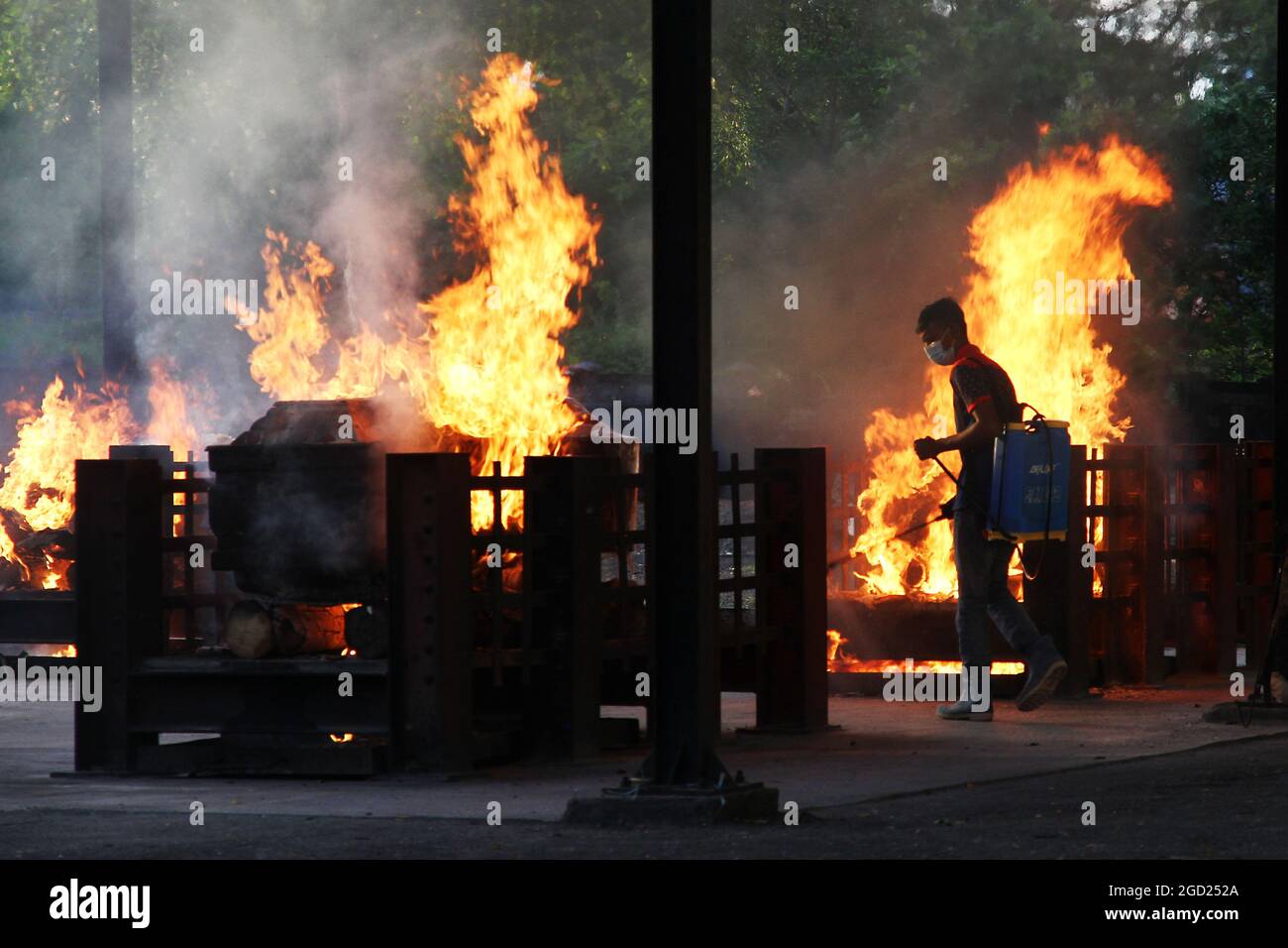 Kuala Lumpur, Malesia. 10 agosto 2021. Un operaio del tempio spruzzi disinfettante durante la cerimonia di cremazione delle vittime di Covid-19 ad un tempiale indù del crematorio a Kuala Lumpur, Malesia. Altri 201 decessi sono stati riportati oggi, portando il numero delle vittime a 11,162. (Credit Image: © Kamal Sellehuddin/ZUMA Press Wire) Foto Stock