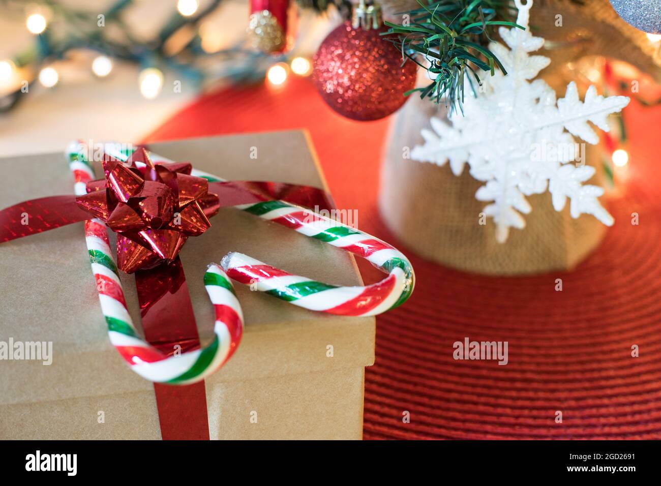 Decorazioni dell'albero di Natale sul tavolo. Concetto di preparazione per Natale e Capodanno. Albero di Natale con scatola regalo e caramelle a forma di cuore. Foto Stock