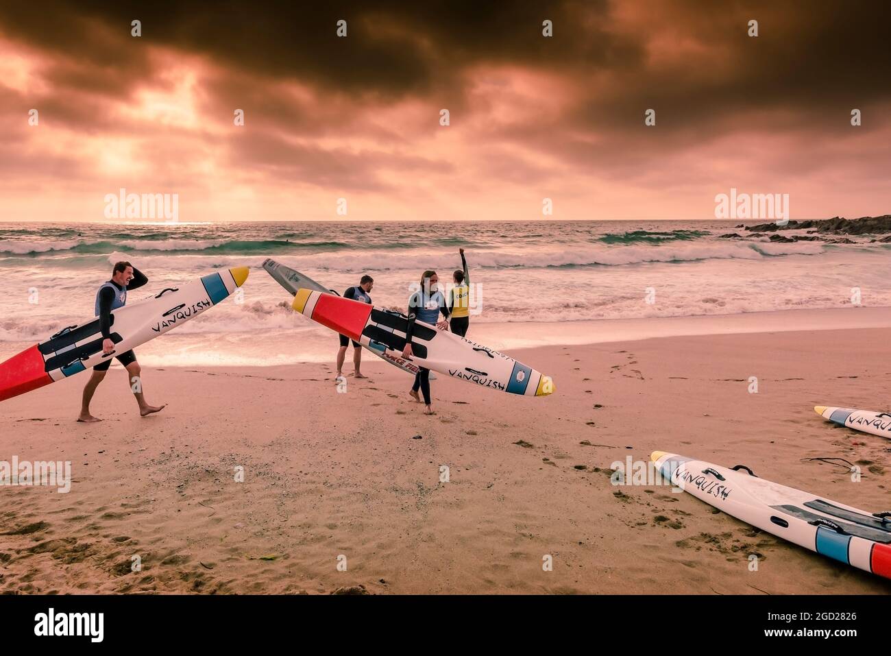 Luce serale sui membri del Newquay Surf Lifesaving Club durante una sessione di allenamento a Fistral Beach a Newquay in Cornovaglia. Foto Stock