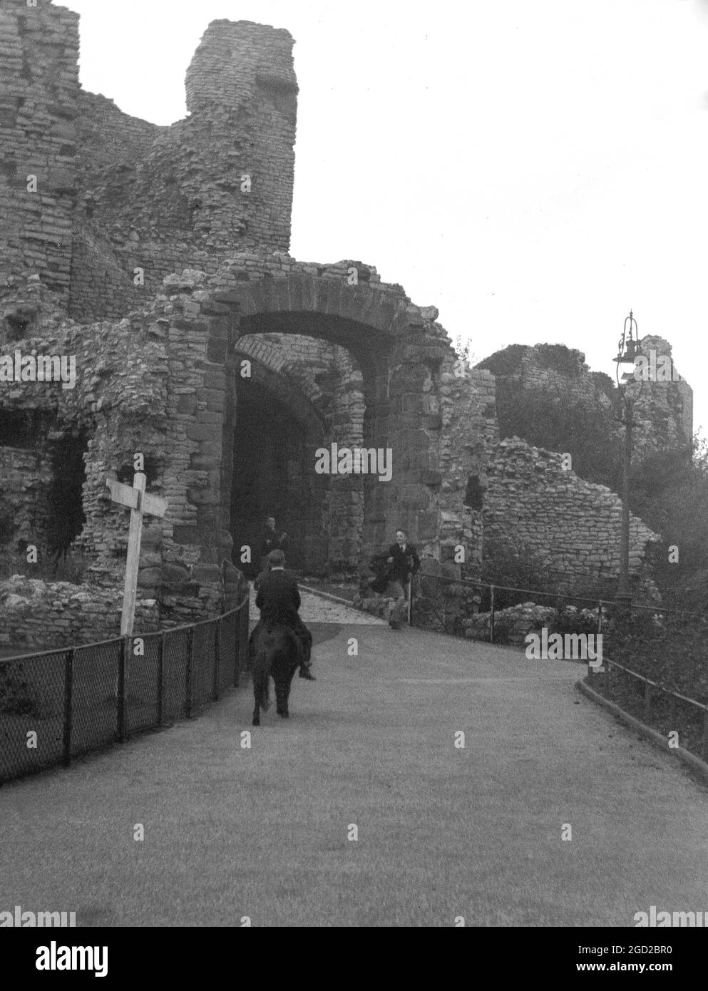 Anni '30, storico, un ragazzo a cavallo di un pony fino all'ingresso delle rovine del castello di Dudley, Inghilterra, Regno Unito. Originariamente un castello di legno motte e bailey costruito dopo la conquista normanna, fu ricostruito come fortificazione in pietra durante il XII secolo, ma successivamente demolito su ordine del re Enrico II. Foto Stock