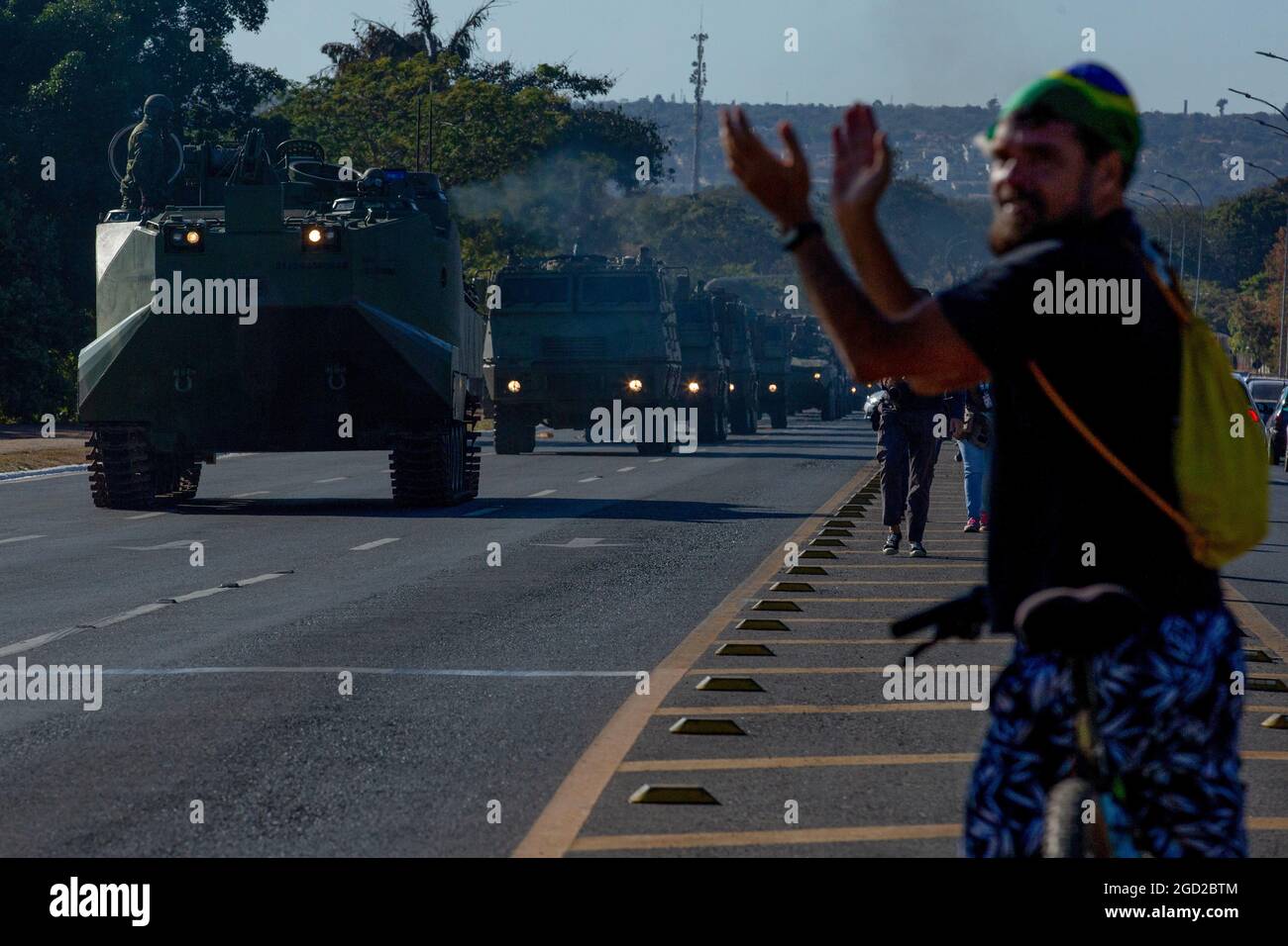 Brasilia, Brasile. 10 agosto 2021. Un uomo che indossa un cappello in colori brasiliani si aggrappò mentre i carri armati lo passavano durante una parata militare. La parata si è svolta il giorno di un voto previsto sulla riforma del sistema elettorale brasiliano. Credit: Myke Sena/dpa/Alamy Live News Foto Stock