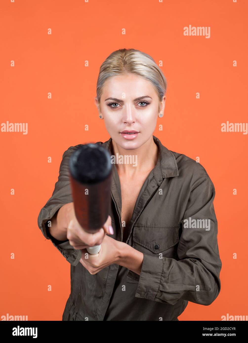 concentration. cricket player su sfondo arancione. donna che tiene attrezzature sportive o accessori. Foto Stock