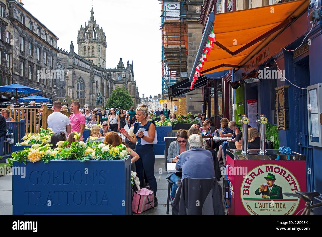 Royal Mile, Edimburgo, Scozia, Regno Unito. 10° Agst 2021. Le folle ritornano ad High Street per questo soleggiato primo lunedì del Fringe Festival, che ha dato agli artisti un pubblico più grande che durante il fine settimana. Nella foto: La Trattoria di Gordon è affollata di clienti nelle aree salotto esterne. Credit: Arch White/Alamy Live News Foto Stock