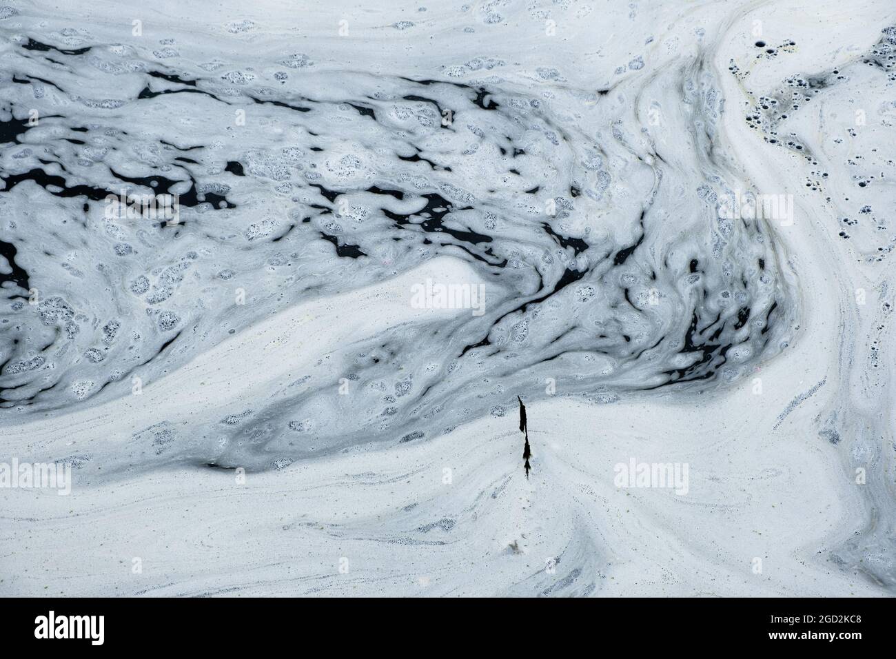 Schiuma bianca, probabilmente il risultato di inquinamento chimico, visto sul fiume Nith, Dumfries, Scozia, 2021. Foto Stock