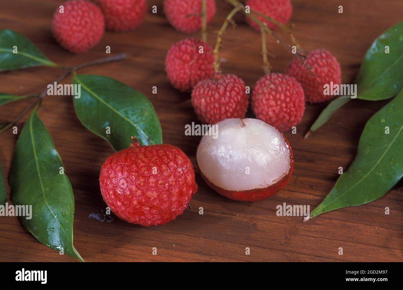 Lychee, litchi chinensis, è stato introdotto per la prima volta nelle Hawaii 100 anni fa, ma è stato coltivato in Cina per quasi 4,000 anni. Sbucciato prima di mangiarlo, il frutto è di colore biancastro, come si vede sulla destra Foto Stock