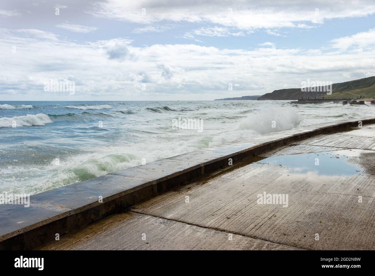 Onde che si infrangono contro le difese marine nello Yorkshire di Scarborough Foto Stock