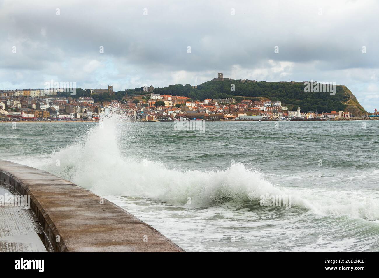 Onde che si infrangono contro le difese marine nello Yorkshire di Scarborough Foto Stock