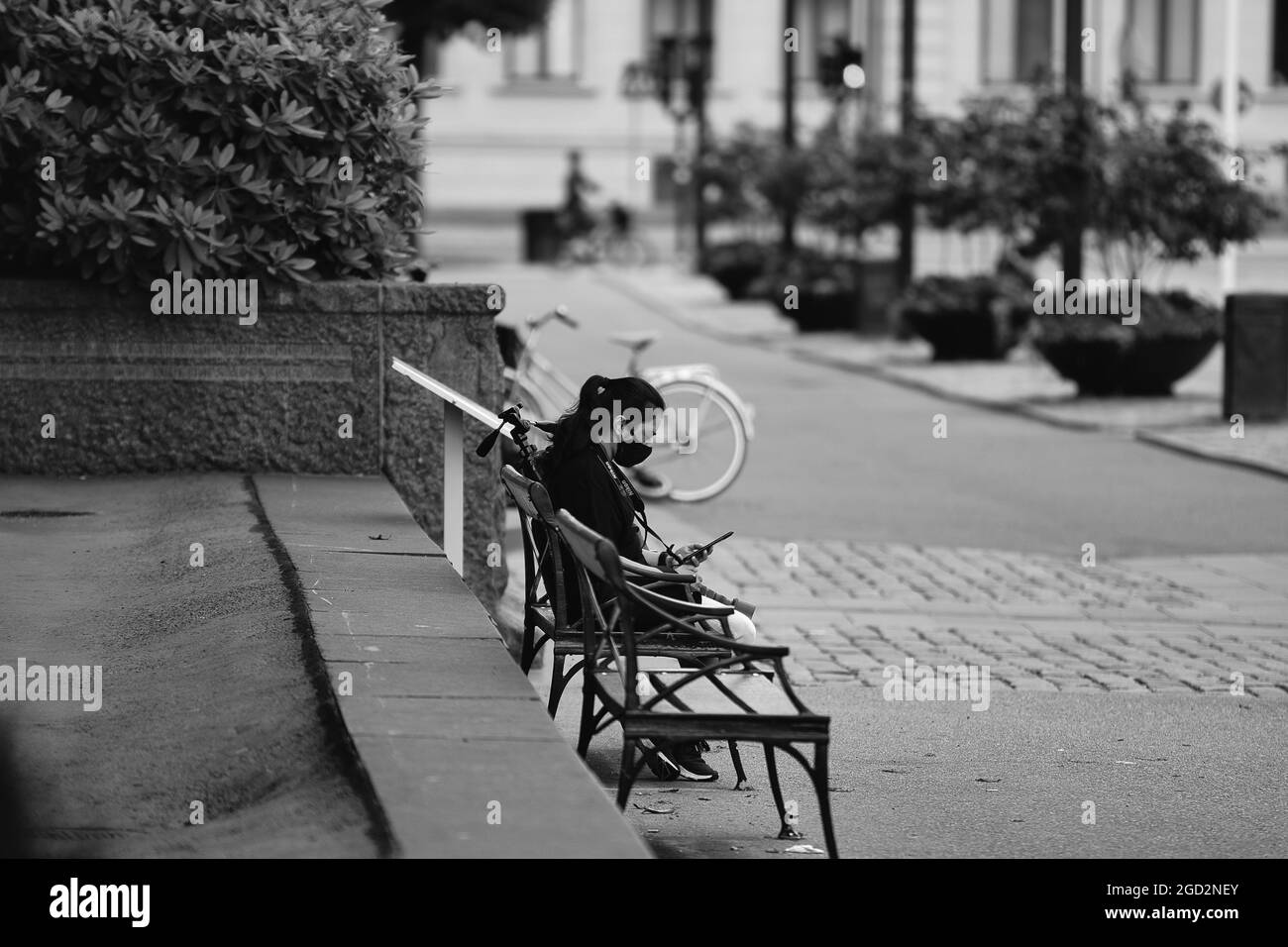 Vista spettacolare di una donna seduta sulla panchina in colore bianco-nero in Svezia Foto Stock