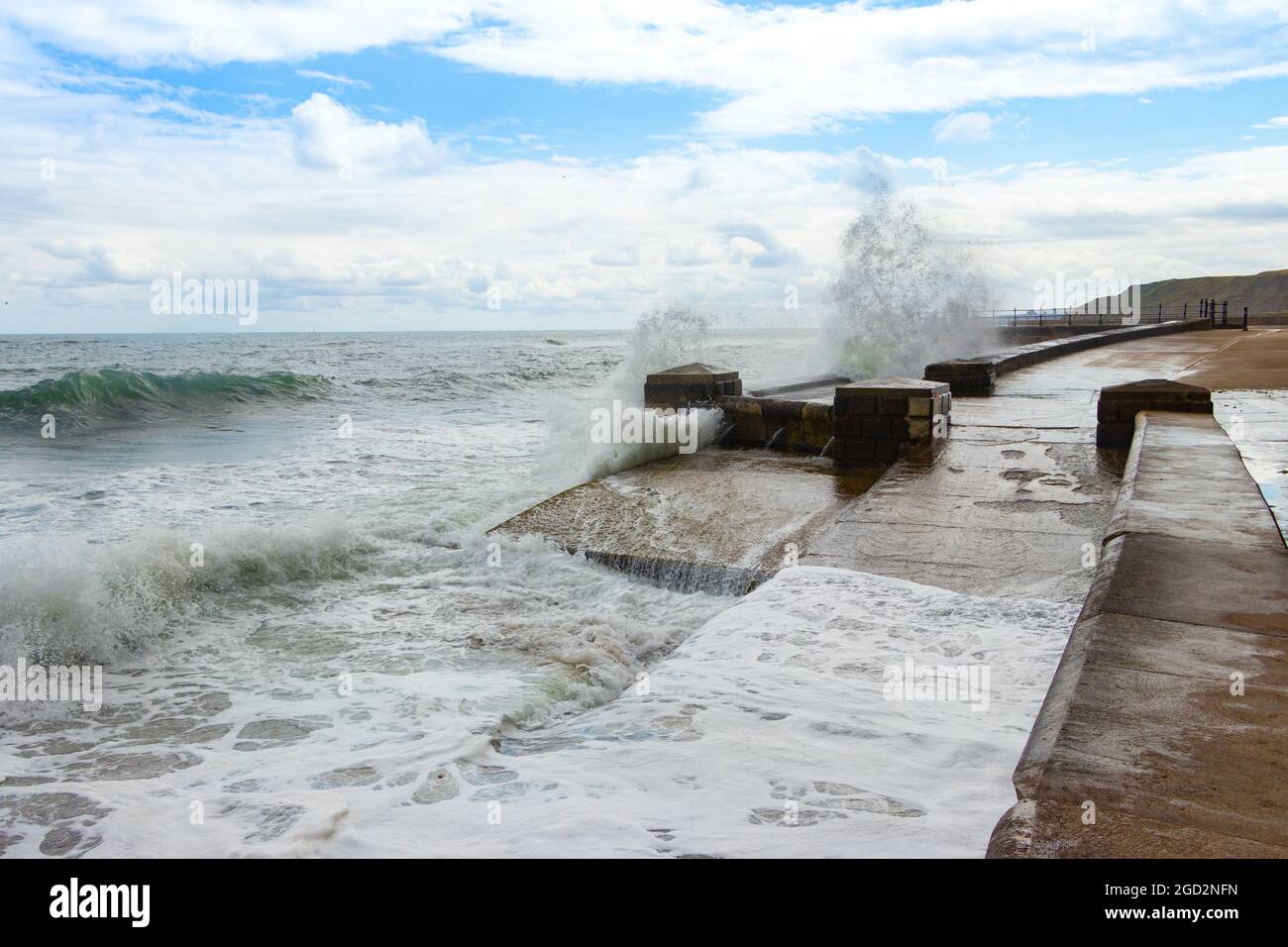 Onde che si infrangono contro le difese marine nello Yorkshire di Scarborough Foto Stock