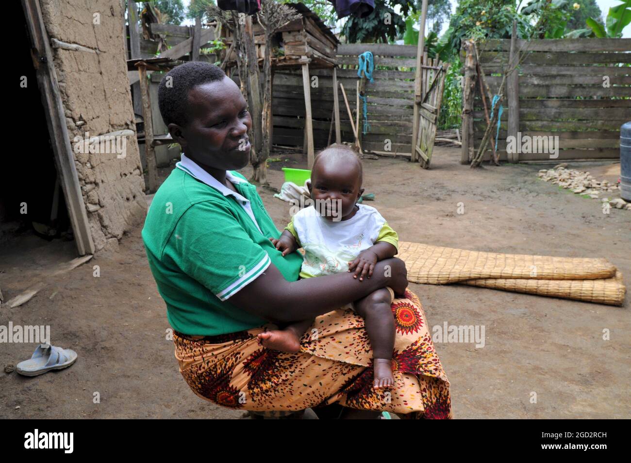 EVA, 34 anni, con la figlia Linette di 8 mesi. EVAs ha una Casa modello nella sua comunità ed è un promotore di gruppo per il gruppo Family Life School nella comunità Bulambira, Ikumba sub-contea ca. 14 marzo 2018 Foto Stock