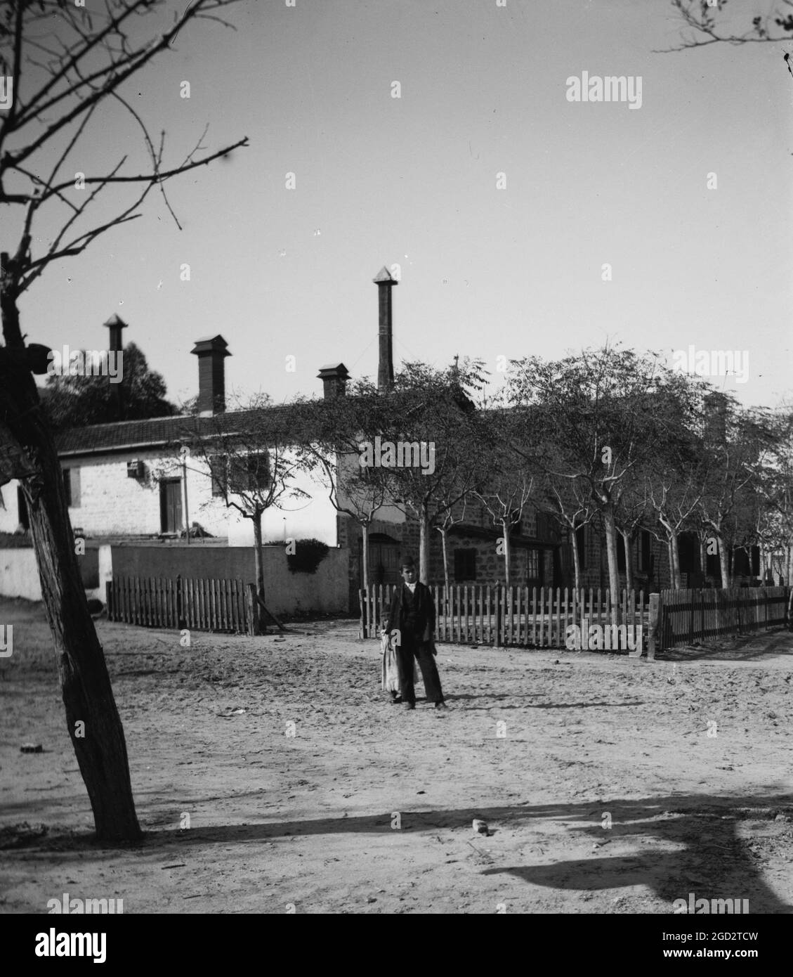 Ragazzo e ragazza timida di fronte alla costruzione in Israele circa tra il 1898 e il 1934 Foto Stock