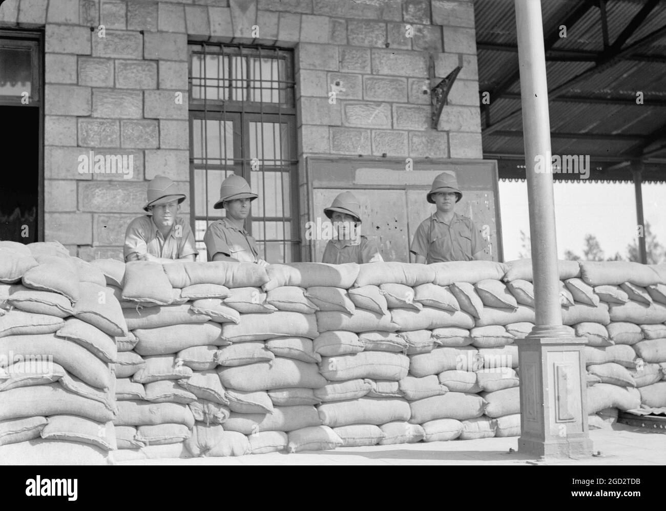 Soldati in piedi dietro sabbia-borsa barricata a Lydda Israele presso la stazione ferroviaria ca. 1939 Foto Stock