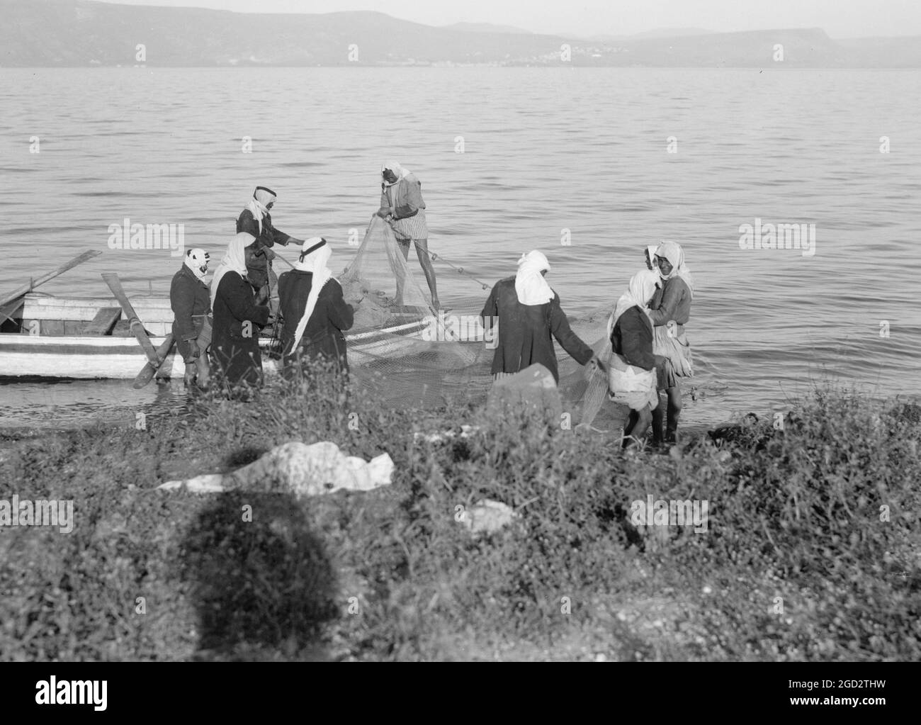 Pescatori arabi che lavorano sulla loro rete sul lato orientale del mare di Galilea ca. Tra il 1934 e il 1939 Foto Stock