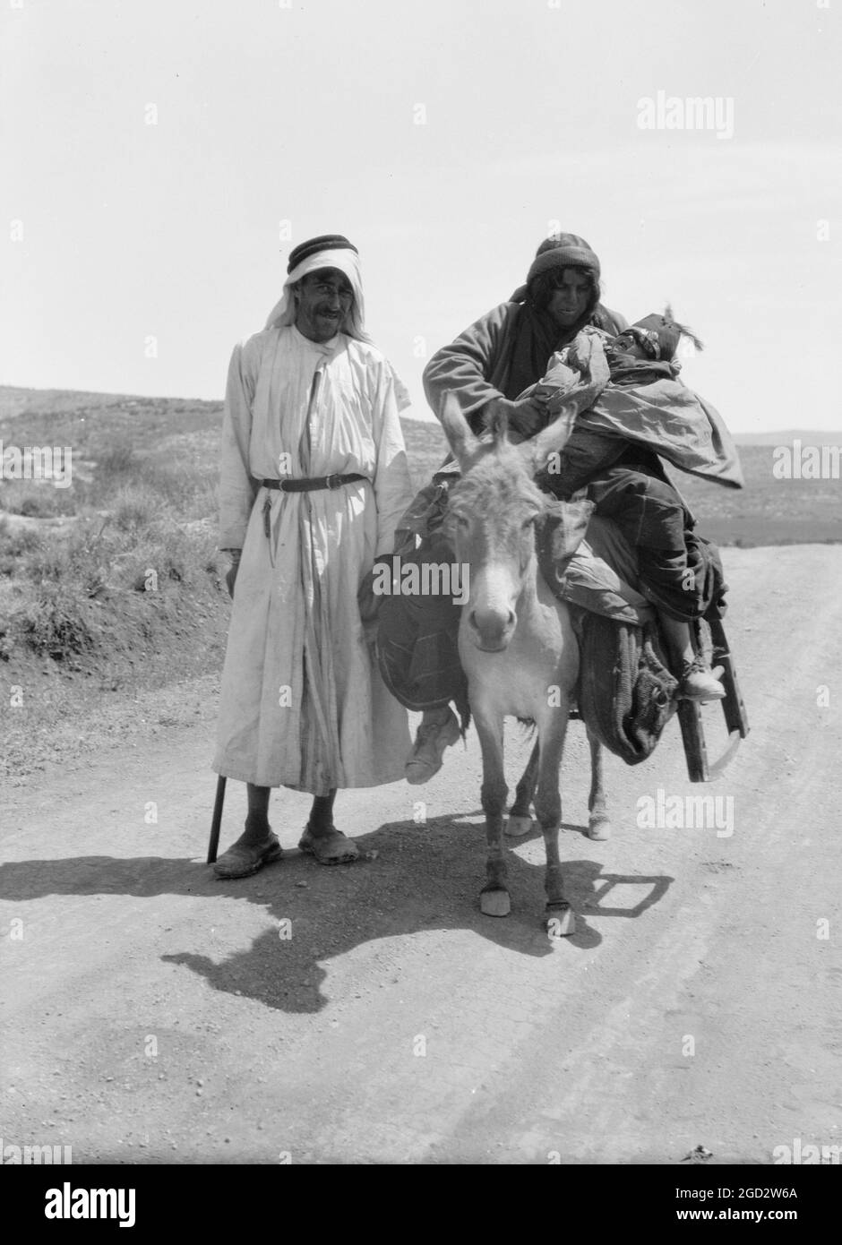 Beduini in Israele, una donna e un bambino su asino, un uomo in piedi circa tra il 1934 e il 1939 Foto Stock