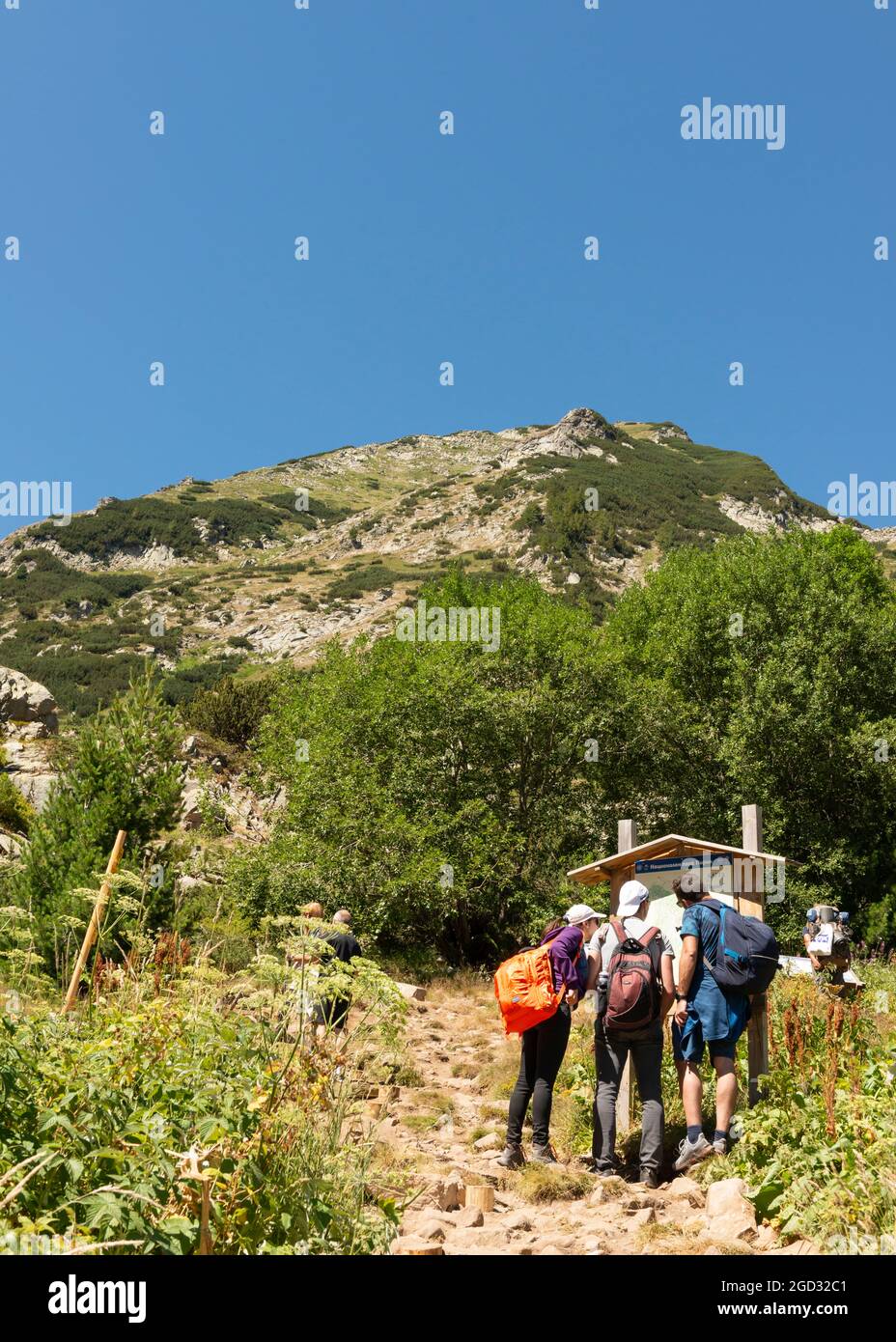Escursionisti esplorare la mappa dei percorsi escursionistici ai piedi del picco Vihren nel Parco Nazionale e Riserva Pirin, Pirin montagna, Bulgaria, Balcani, Europa Foto Stock