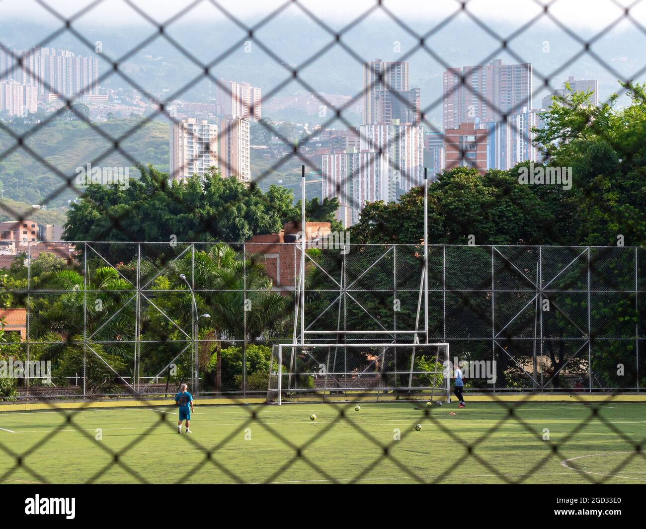 Medellin, Colombia - Luglio 30 2021: Due giovani Latinos che addestrano il calcio con parecchie sfere in un giorno di sole Foto Stock