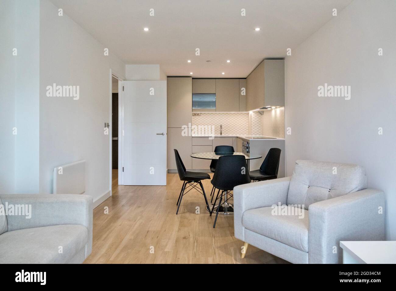 Una cucina e un soggiorno nuovi, vuoti, a pianta aperta in un moderno complesso di appartamenti nel Nord di Londra. L'albergo residenziale è decorato con pareti bianche. Foto Stock