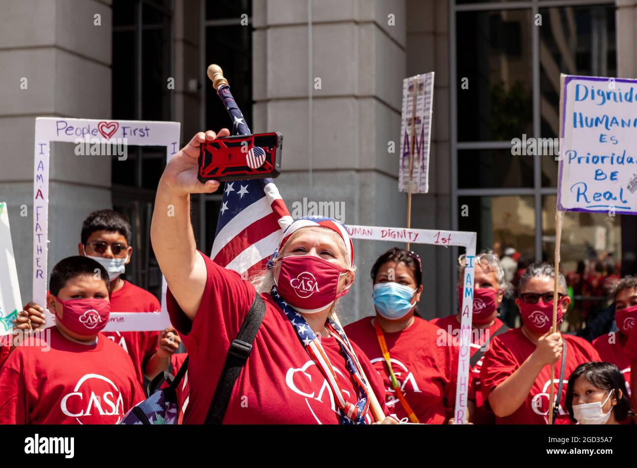 Washington, DC, USA, 10 agosto 2021. Nella foto: Un membro del consiglio DI AMMINISTRAZIONE DI CASA prende un selfie con un gruppo di persone in un rally che chiede che l'immigrazione e l'applicazione doganale (ICE) trattano gli immigrati come persone, non semplicemente come categorie "prioritarie" o "non prioritarie". I manifestanti hanno utilizzato cornici per sottolineare che gli immigrati sono persone, non categorie. Credit: Alison Bailey / Alamy Live News Foto Stock