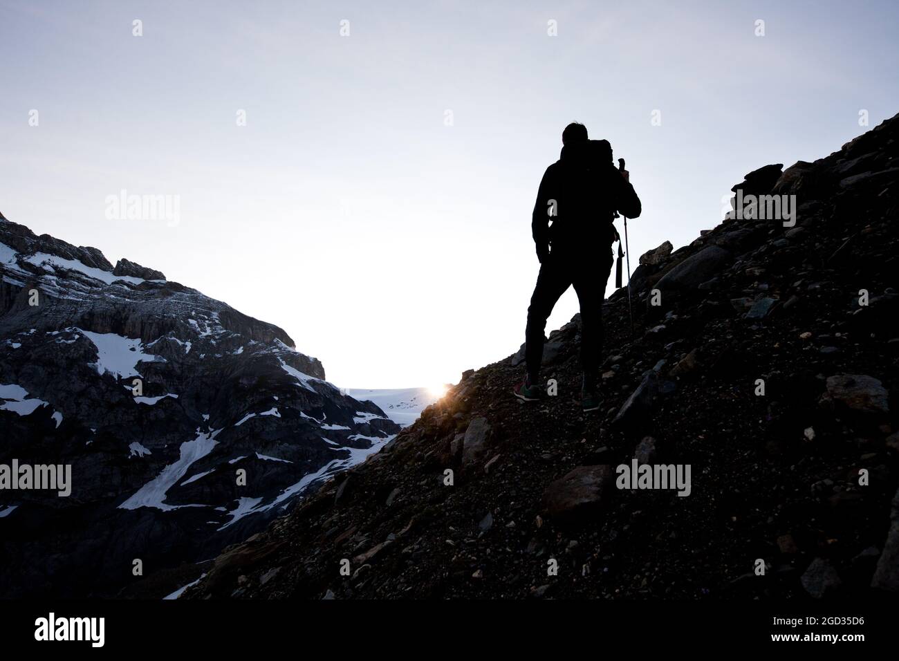 Un uomo in piedi sulla cima di una montagna innevata Foto Stock