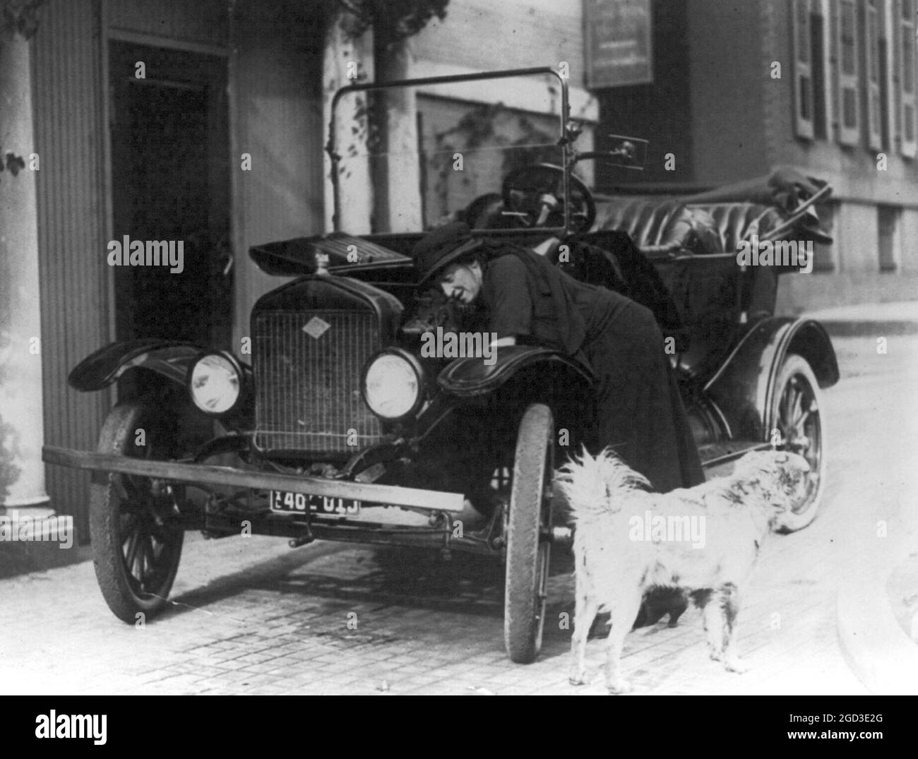 Miss Maude Younger di San Francisco, Segretario legislativo del Partito Nazionale delle Donne, che è arrivato a Washington per partecipare alla Convention of the Womans Party, lavorando sulla sua auto Ford - il suo cane, Sandy, è in primo piano tra il 1909 e il 1932 Foto Stock